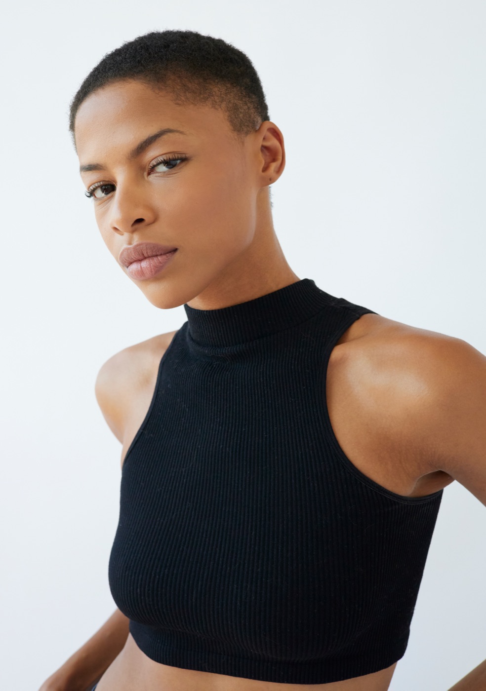 RiRi, beauty model, natural-glam portrait looking over the shoulder in a black sleeveless top
